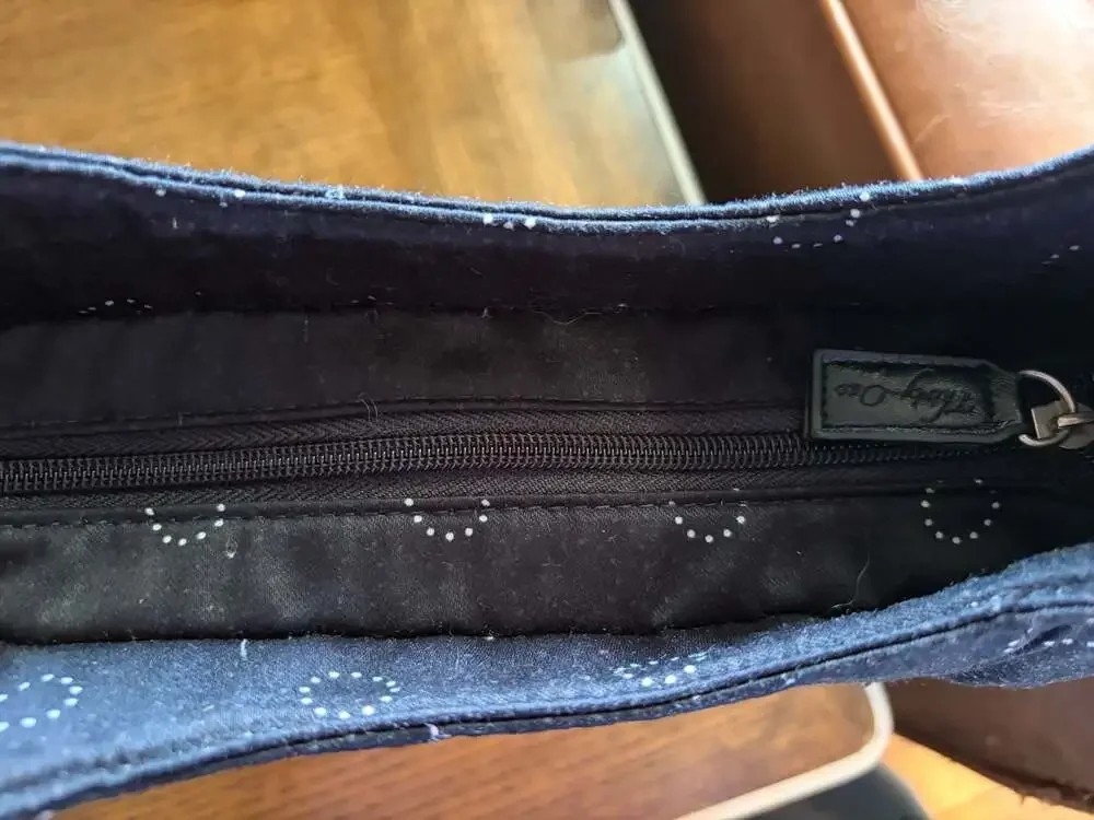Thirty-One black hobo shoulder bag with white polka dot circles and striped inte